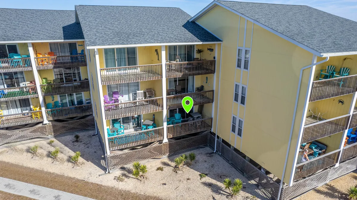 This image showcases the exterior of the condo complex with colorful balconies, inviting outdoor seating, and lush landscaping. The atmosphere is cheerful and relaxed, highlighting spaces where guests can lounge, socialize, or enjoy quiet mornings surrounded by nature.